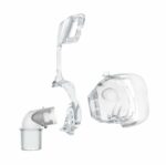 Three clear plastic CPAP mask parts, including a cushion, elbow connector, and headgear frame, on a white background.