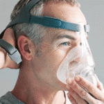 Man putting on a CPAP mask for sleep apnea therapy.