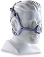 A mannequin head wearing a CPAP nasal mask with adjustable straps around the face and head.