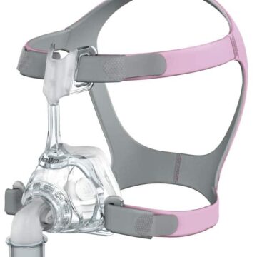 A pink and gray CPAP mask and headgear, designed for sleep apnea therapy, shown on a white background.
