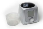 A CPAP machine with a display screen and a detached water chamber on a white background.