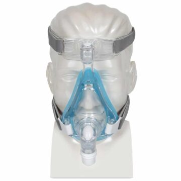 Clear mannequin head wearing a full-face CPAP mask with blue and gray straps, shown from the front.