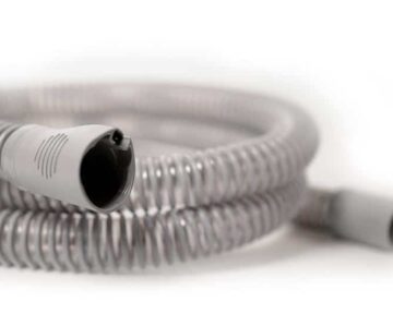 Coiled gray plastic hose with connectors on each end, set against a white background.