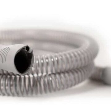 Coiled gray plastic hose with connectors on each end, set against a white background.
