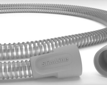 Close-up of a gray, flexible SlimLine medical hose with ribbed texture and connectors at both ends.