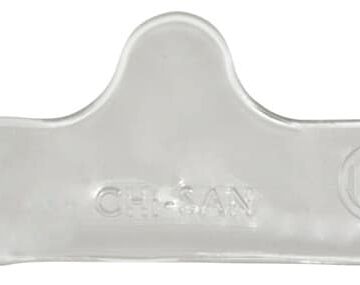 Clear plastic dental cheek retractor with a raised center and rounded ends, embossed with a logo and text.