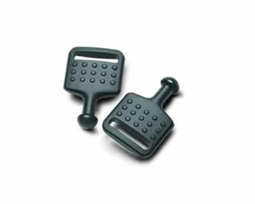 Two black plastic knobbed paddle tools with dotted surfaces, lying on a white background.