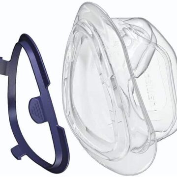 Clear plastic CPAP mask cushion and a separate blue mask frame shown side by side on a white background.