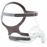 CPAP nasal mask with clear plastic nasal piece and gray adjustable headgear straps.