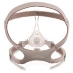 A CPAP nasal mask with a gray headgear strap and clear nose piece, shown from the front.