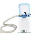 SoClean CPAP sanitizer with open lid, attached hose, and mask placed inside for cleaning.