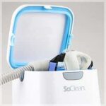 A SoClean machine with its lid open, sanitizing a CPAP mask inside.