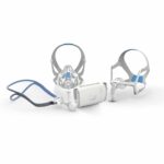 Three different CPAP masks and a small white CPAP machine displayed on a white background.