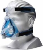 A mannequin head wearing a clear and blue CPAP face mask with black head straps.