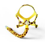 A CPAP mask with a yellow and brown giraffe print design on a white background.