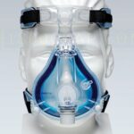 A mannequin head wearing a clear blue full-face CPAP mask with black head straps.