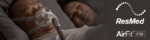 A man is wearing a ResMed AirFit F30 Full Face CPAP Mask in bed.