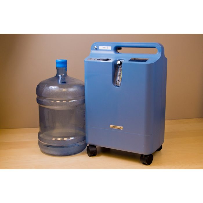 A Respironics Everflo Stationary Concentrator next to a bottle of water.