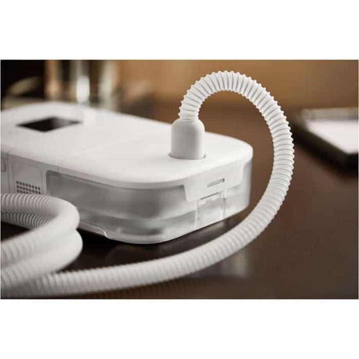 A white Phillips Respironics Dreamstation Go Heated Humidifier with a hose.