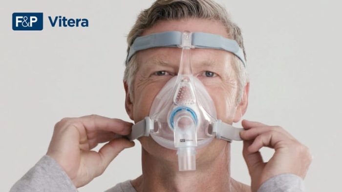 A man wearing a Fisher & Paykel Vitera Full Face CPAP Mask.