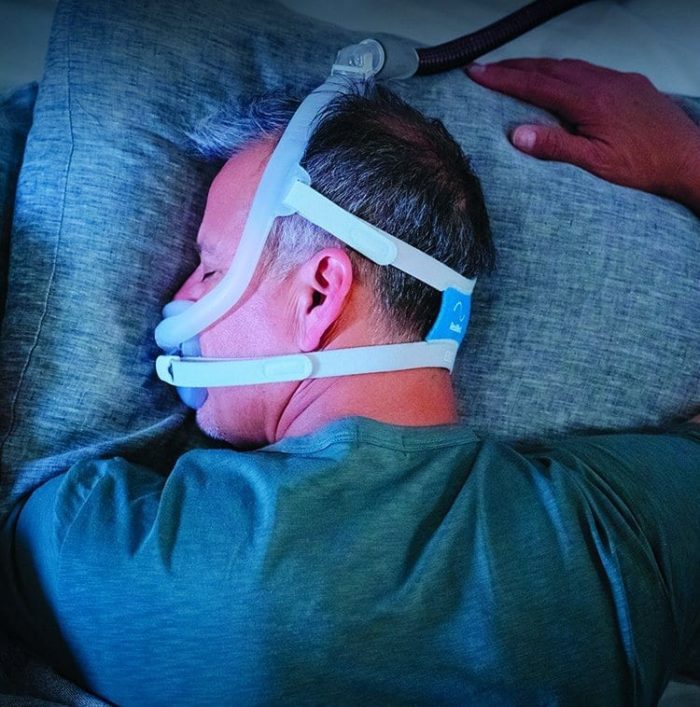 A man wearing the ResMed AirFit F30i Full Face CPAP Mask product name while sleeping.