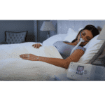 A woman using a ResMed AirSense S10 Autoset for Her APAP Machine with HumidAir Humidifier in bed.