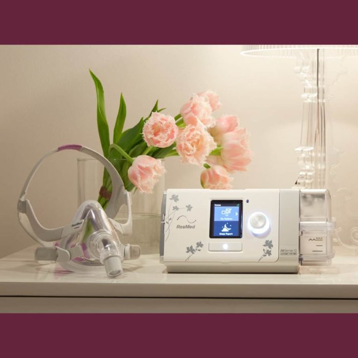 A discounted bedside table with a ResMed AirSense S10 Autoset for Her APAP Machine with HumidAir Humidifier and flowers.