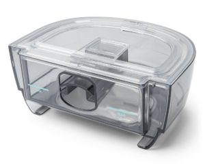 A clear plastic Respironics Dreamstation 2 Humidifier Chamber with a lid on it.