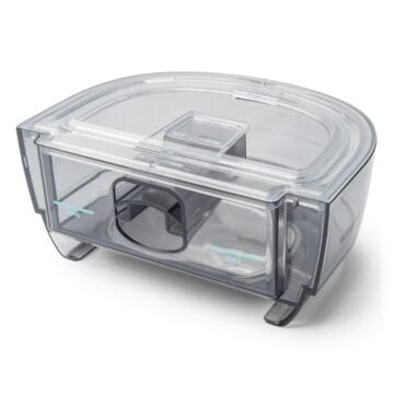 A clear plastic Respironics Dreamstation 2 Humidifier Chamber with a lid on it.