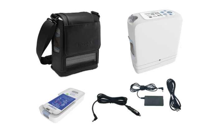 An Inogen One G5 Portable Oxygen Concentrator with 16 Cell Battery/Extended Life Battery and a bag with a charger.