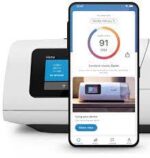 A smartphone displaying a health score app in front of a ResMed AirCurve 11 Bi-Level VAuto Machine with HumidAir Humidifier and digital screen.