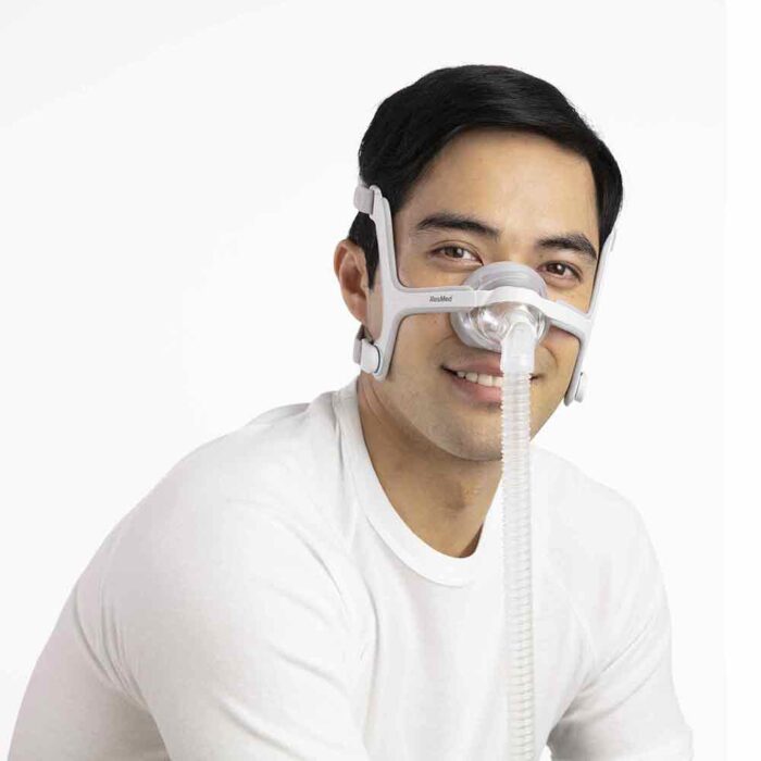 A man in a white shirt wearing a ResMed Airtouch N20 Nasal CPAP Mask, smiling at the camera against a white background.
