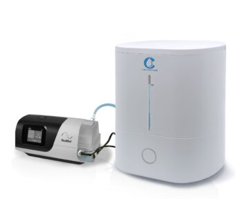 The CSpring MK3 Automatic CPAP Water Chamber Replenishing System connects to a white CPAP water chamber humidifier with a display screen and tubing.
