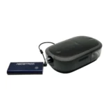 Medistrom Pilot Flex CPAP Battery (Charcoal Black) connected to a black CPAP machine via cable, shown on a white background.