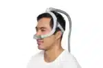 Man wearing the ResMed AirTouch N30i Nasal CPAP Mask (Fit Pack) with headgear and hose for sleep apnea therapy, shown on a white background. Fit Pack offers multiple cushion sizes for optimal comfort and effective treatment.
