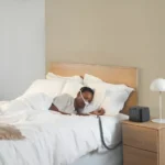 Person sleeping in bed with a Fisher & Paykel Solo Nasal CPAP Mask (Fit Pack), connected to a bedside machine, for restful sleep.