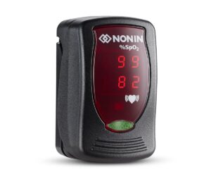 A Nonin Onyx Vantage 9590 Finger Pulse Oximeter in black shows 99% SpO2 and a pulse rate of 82 on its red digital screen.