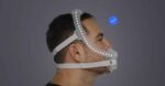 Side view of a man wearing the ResMed AirFit X30i Full Face CPAP Mask with head straps, featuring a dotted line that highlights the airflow path.