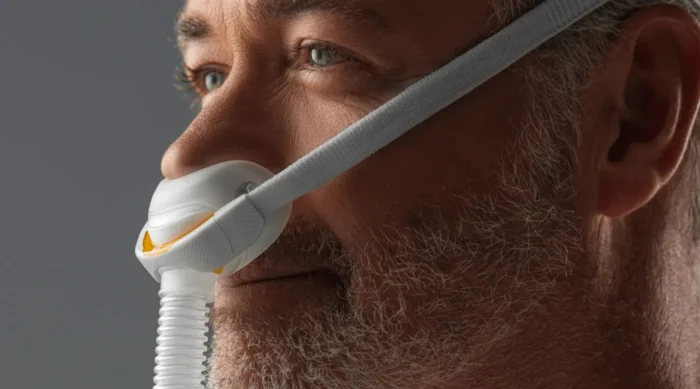 Close-up of a man wearing the Fisher & Paykel Solo Nasal CPAP Mask (Fit Pack), highlighting mask details and his facial features.
