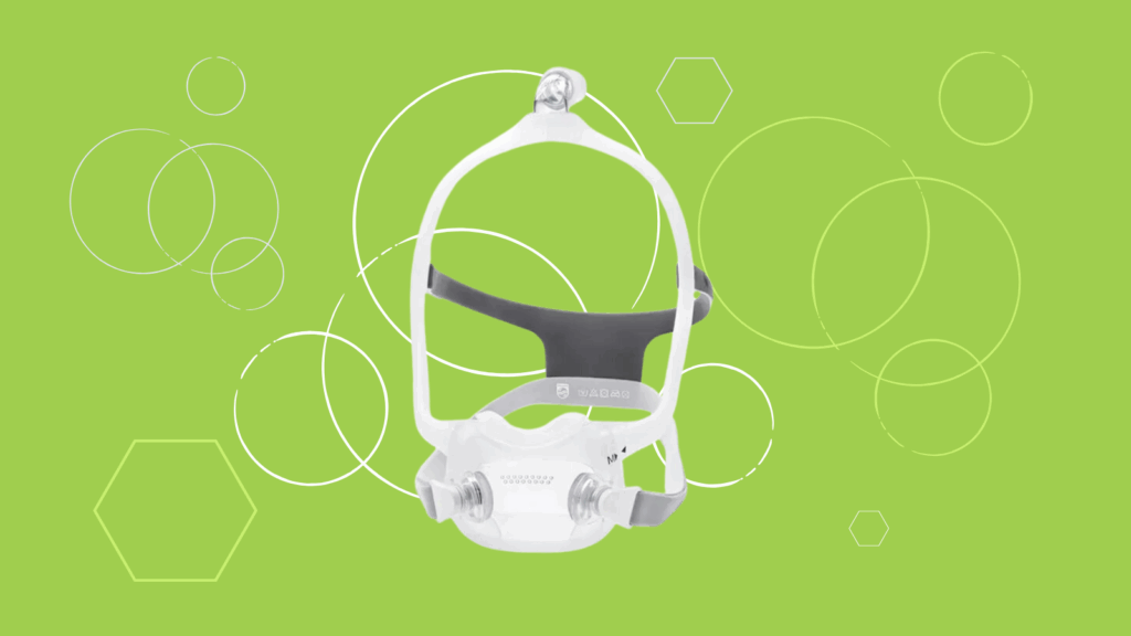 A Dreamwear Full Face CPAP Mask is displayed on a green background with white geometric shapes, ideal for any Respironics CPAP Mask review.