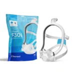 A CPAP face mask with headgear is shown next to its blue ResMed AirFit F30i Comfort Full Face CPAP Mask Cushion packaging, perfect for those needing a ResMed AirFit F30i mask cushion replacement.