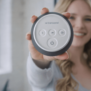 Woman holding a Graphite Gray Transcend Micro 510 travel CPAP, showing the top control buttons